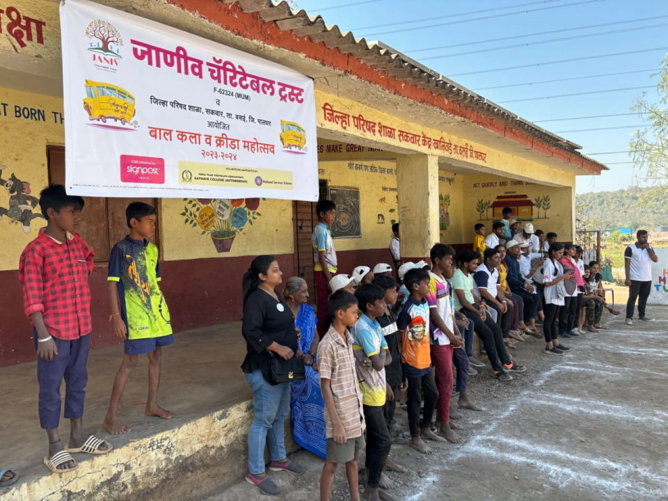 Children and volunteers beside the ‘बाल कला व क्रीडा महोत्सव 2023-24’ banner at Zilla Parishad School, Sakwar